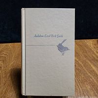 Front cover of beige cloth hardcover showing title and bird silhouette