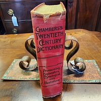 Front spine view showing title, red cloth, top spine tear