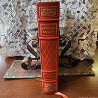 Spine view showing red leather, gilt titles and lattice pattern