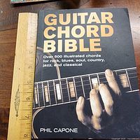 Front cover of Guitar Chord Bible next to ruler