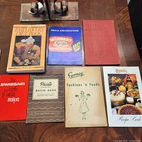 Front covers of all seven recipe booklets laid out on table