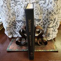 Spine of Medusa hardcover between metal bookends