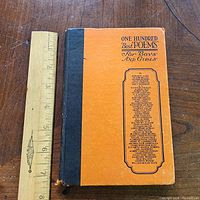 Front cover of orange and black quarter-bound hardcover with ruler for scale