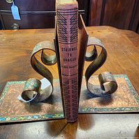 Book standing between metal bookends showing spine title and publisher