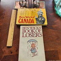 Front covers of both books beside ruler for scale