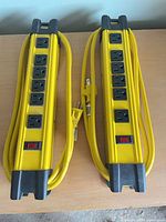 Front view of two yellow metal power bars showing 8 outlets and power switch