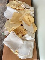 Pile of folded cream and yellow cloth napkins on surface