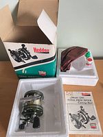 Box, reel in styrofoam, cloth pouch, oil bottle, manual