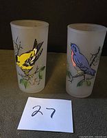 Two frosted glass tumblers with bird designs side by side