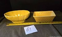 Both yellow planters side by side with tape measure