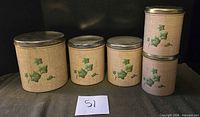 Front view of all five canisters showing size gradation and ivy pattern