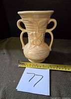 Front view showing floral relief, double handles, ruler for scale