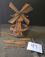 full view of wooden windmill lamp with detached sail parts in foreground