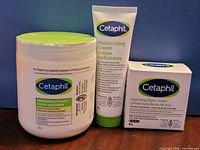 Front view of three unopened Cetaphil moisturizers: jar, tube, boxed night cream