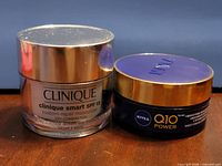 Front view of both unopened jars: Clinique Smart Custom-Repair Moisturizer and Nivea Q10 Power Night Cream