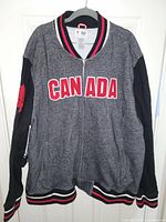 Front view of grey and black full-zip CANADA sweater