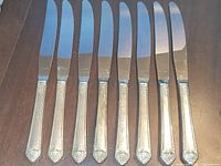 All eight knives laid flat, showing full handles and blades