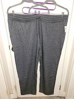 Full view of grey sweatpants hanging