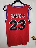 Back of red Tune Squad jersey showing JORDAN and 23
