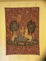 Medieval-style tapestry featuring woman with lion and unicorn under trees