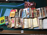 Books laid out on a green surface, showing various covers with colorful artwork and titles focused on culinary subjects.