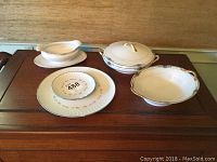 Photo showing the full assortment of Noritake china items on a wooden surface, including serving dishes and plates.
