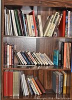 Shelf with multiple books of various historical and political titles in hardcover and paperback.