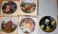 Photo of six collector plates, four Edwin M. Knowles plates in original packaging and two W. J. George plates including a panda plate