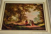 Framed print showing three robed figures walking on wooded path with large trees and greenery under golden sky.