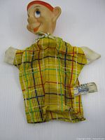 Front view of Dopey puppet showing head, cloth body and tag