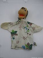 Front view of Pluto hand puppet showing head and floral cloth body