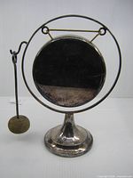 Front view of silver-plated dinner gong on pedestal stand