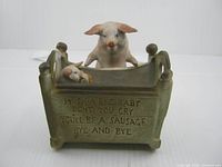 Front view showing adult pig, piglet in cradle, inscription on cradle front