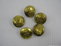 Front view of five uniform buttons showing crown and monogram detail