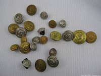 Group view of 22 Canadian National Railways metal uniform buttons in mixed finishes and sizes