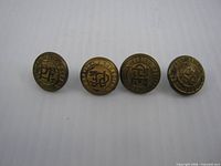 front view of four brass Canadian Pacific Express buttons in a row