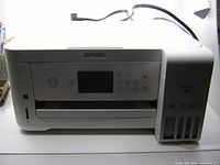 Front view of Epson ET-2760 printer showing control panel and EcoTank reservoirs