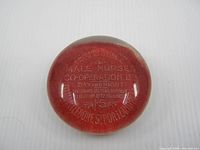 Front view of glass paperweight showing full inscription and domed shape