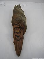 Front view of carved wooden face wall hanging