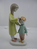 Front left view of figurine showing girl touching boy's hair