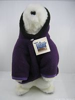 Front view of polar bear plush in purple parka with Taluq tag