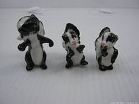 front view of three skunk figurines