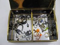 Open jewelry box showing mirrored interior and assorted body jewelry inside