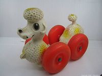 Left front perspective showing poodle figure and red wheels