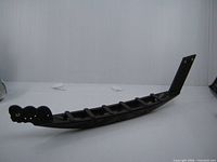 Full side view of carved wooden war canoe model