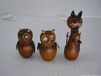 Front view of three teak brooches: two owls and cat with mouse