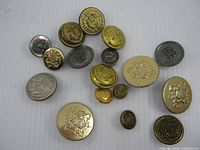 Full group of 17 mixed metal buttons displayed on white background
