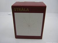 Front of maroon STRÅLA box showing product illustration