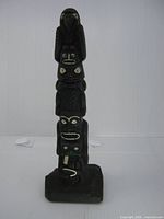 Front view of black plastic totem pole on base