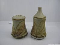 Front view of both stoneware shakers showing shapes and glaze pattern